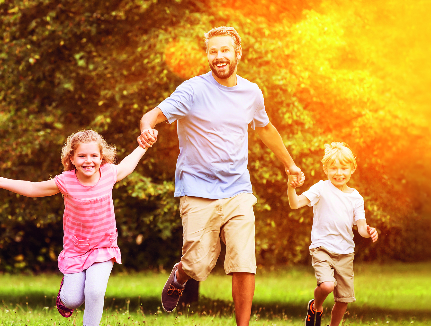 Glückliche Familie und Kinder laufen zusammen im Garten im Sommer